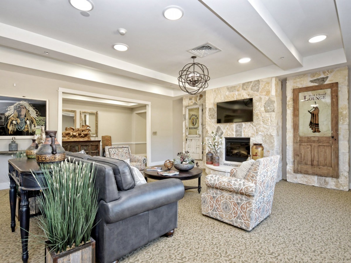 A modern living room with comfortable furniture, featuring a fireplace and a television.