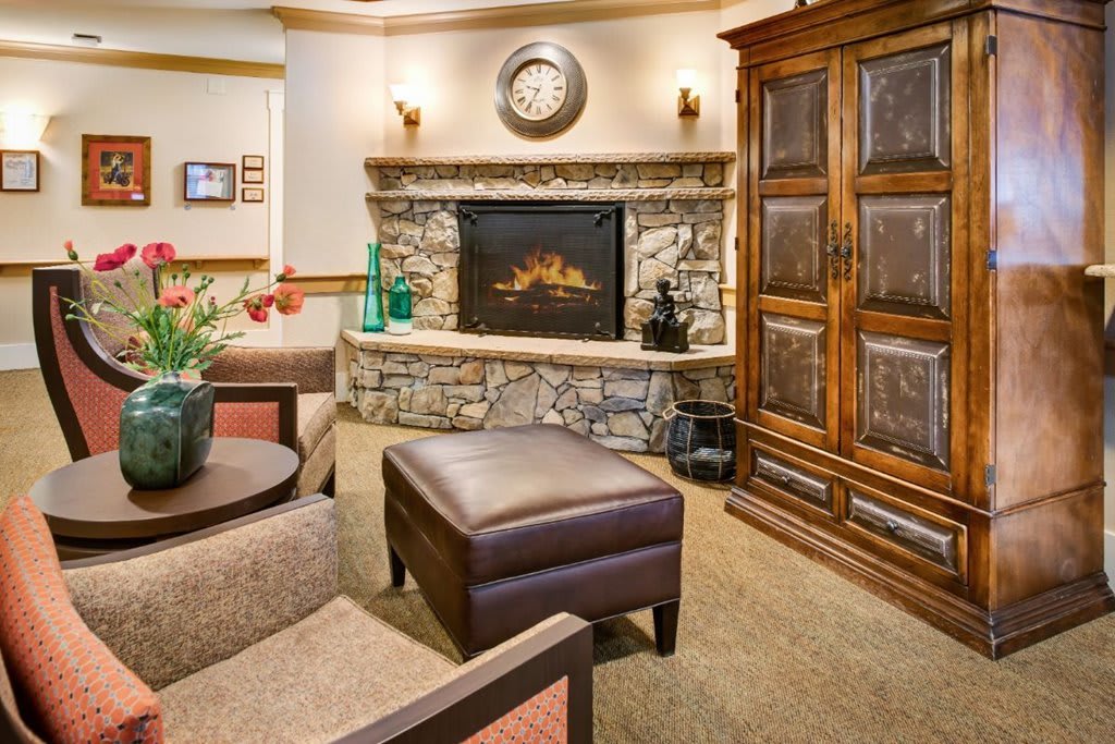 A cozy living room with a stone fireplace and comfortable seating.