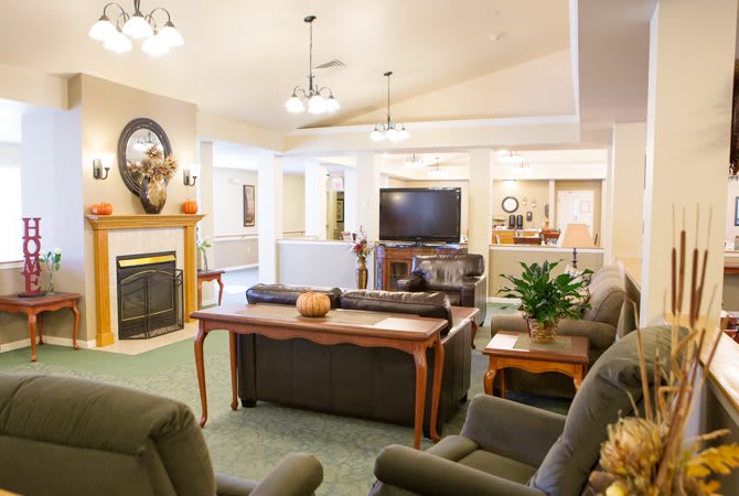 A cozy living room with a fireplace, comfortable seating, and a television.