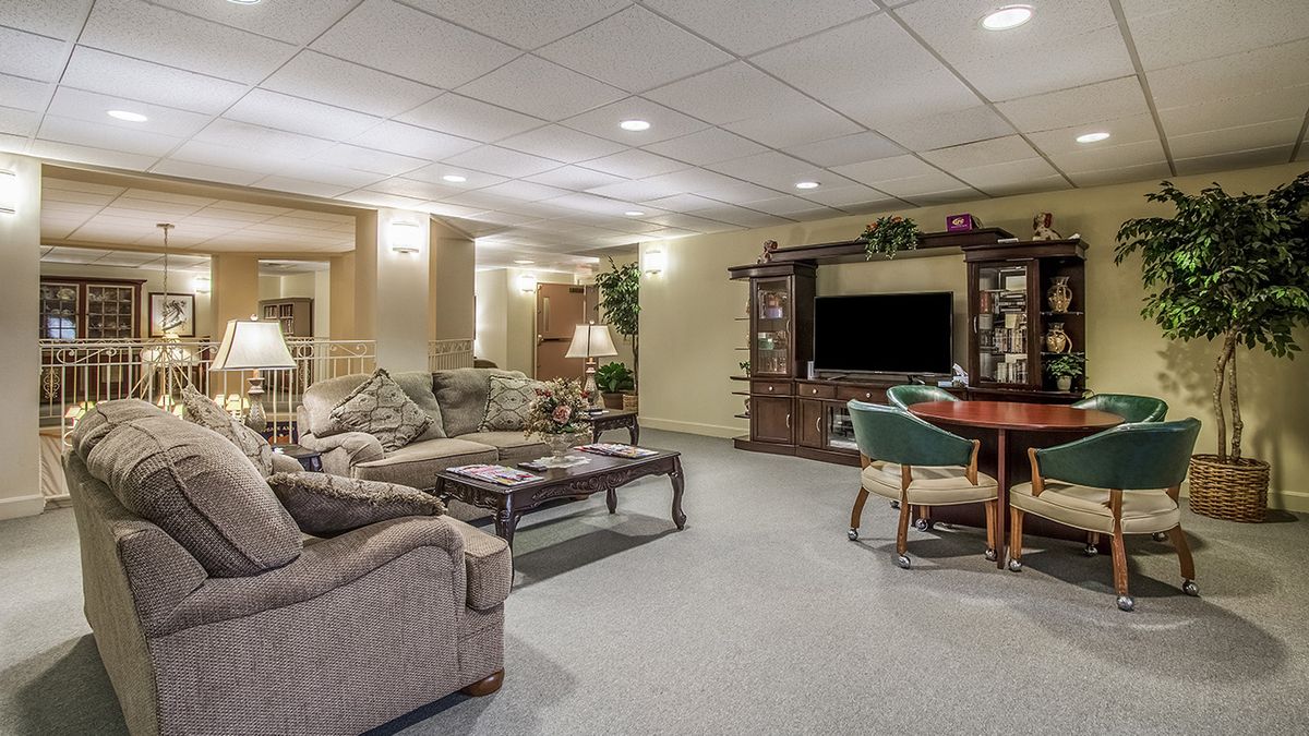 A cozy living room area featuring a sofa, television, and wooden furniture.