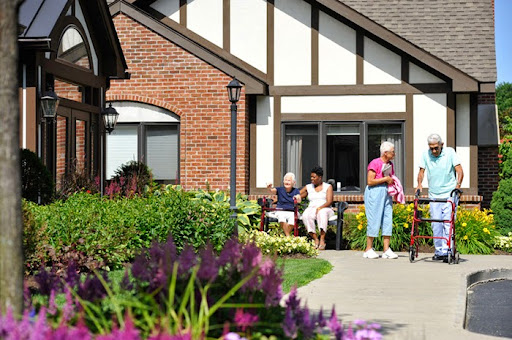 Seniors enjoy a sunny day in the garden of their residential facility.