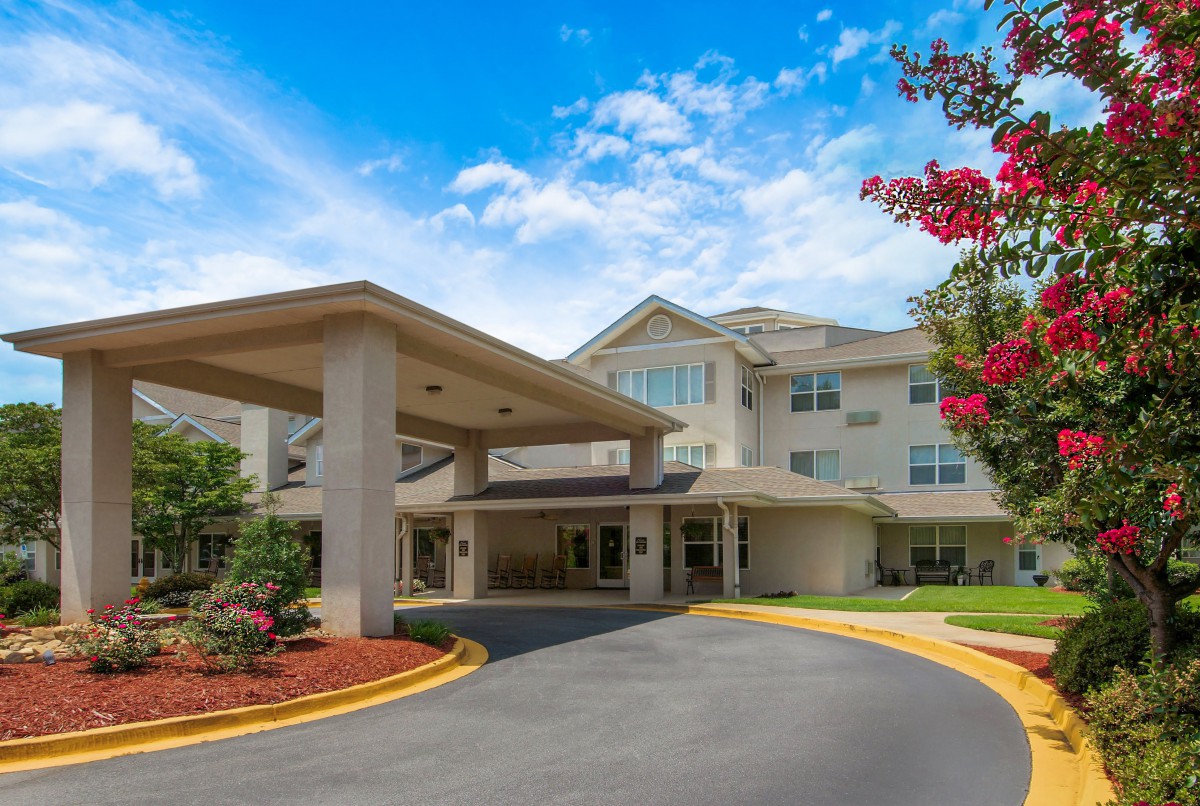 A welcoming entrance with landscaped surroundings under a bright blue sky.