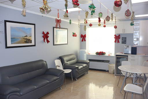 A decorated waiting room with holiday-themed embellishments, featuring grey sofas and bright natural light.