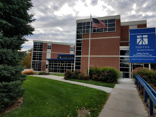 An educational building with modern architecture, featuring large windows and an American flag.
