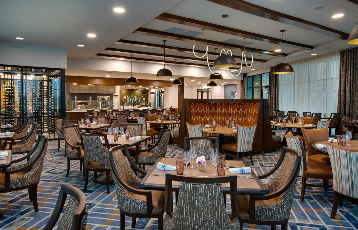 A modern and elegantly decorated restaurant interior with neatly arranged tables and chairs.