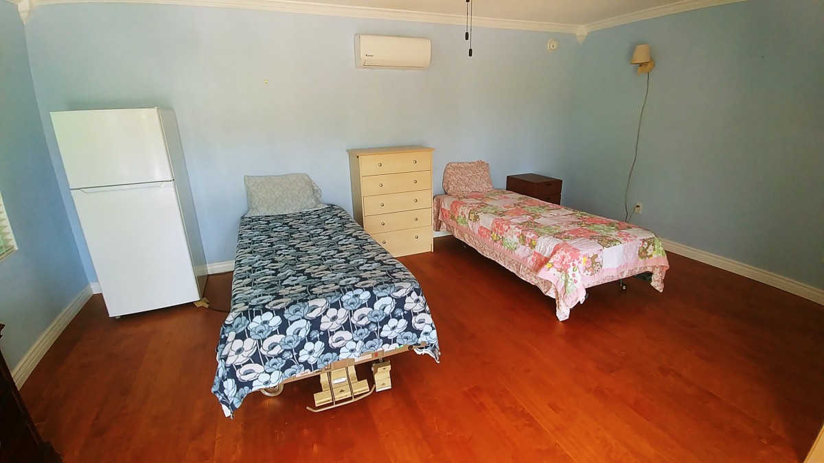 A bedroom with two single beds and wooden flooring.
