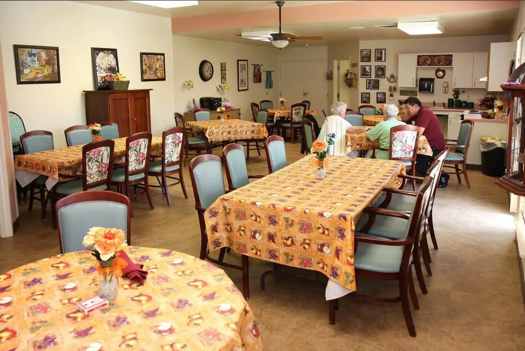 A communal dining area with tables covered in festive tablecloths and seating for multiple people.
