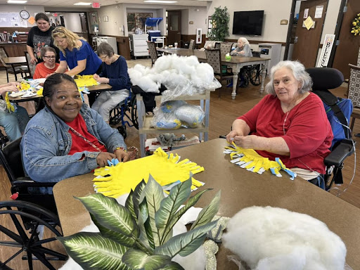 Residents engaging in a crafting activity at an assisted living facility.