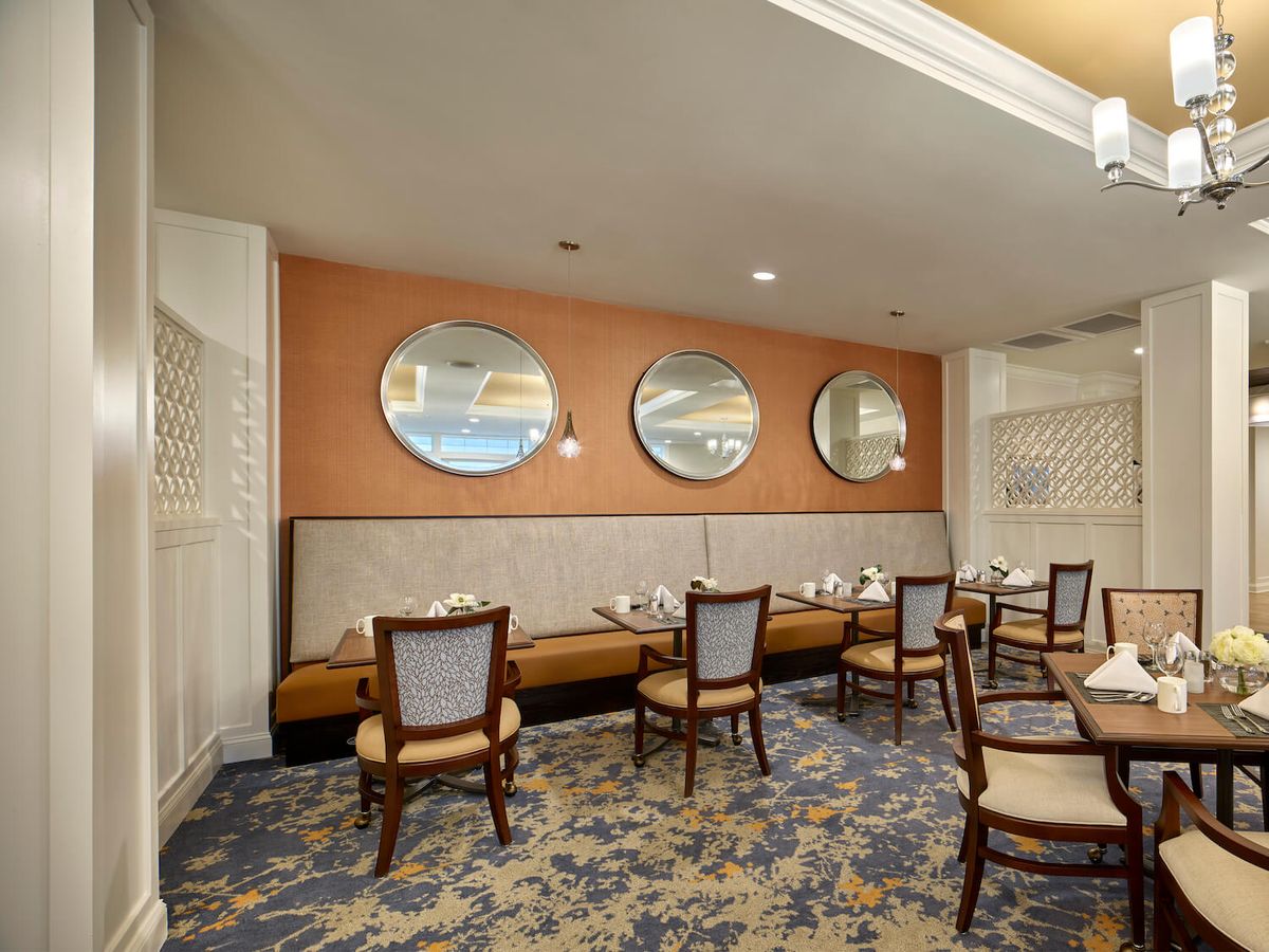 A cozy dining area with stylish mirrors and elegant chairs.