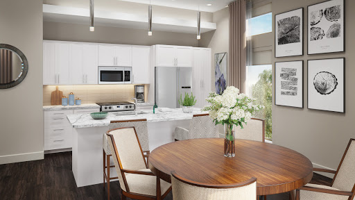 A beautifully designed modern kitchen featuring sleek white cabinetry and a cozy dining area with floral accents.