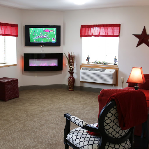 A cozy living room featuring a modern TV, comfortable seating, and decorative elements.