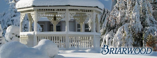 A snow-covered gazebo surrounded by a serene winter landscape.