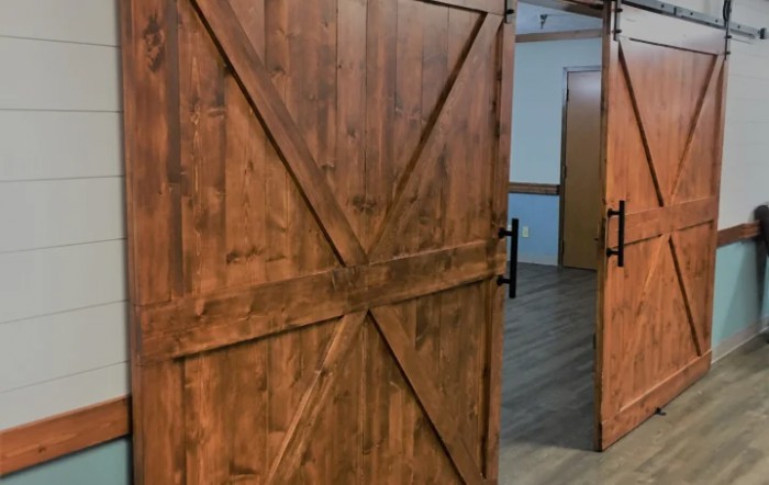 A rustic wooden sliding barn door in an interior setting.