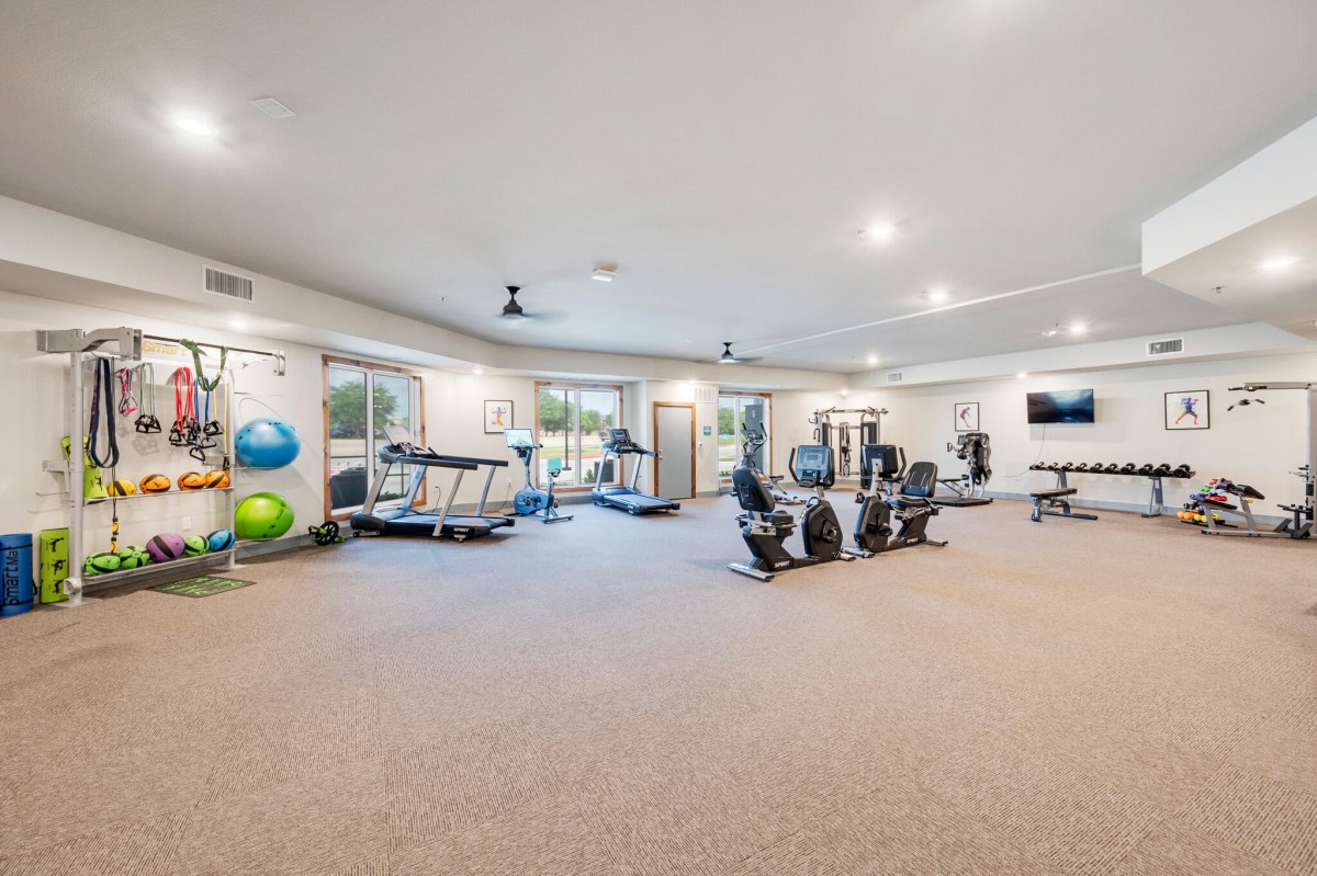 A spacious and modern fitness center with various exercise equipment, including treadmills and weights.