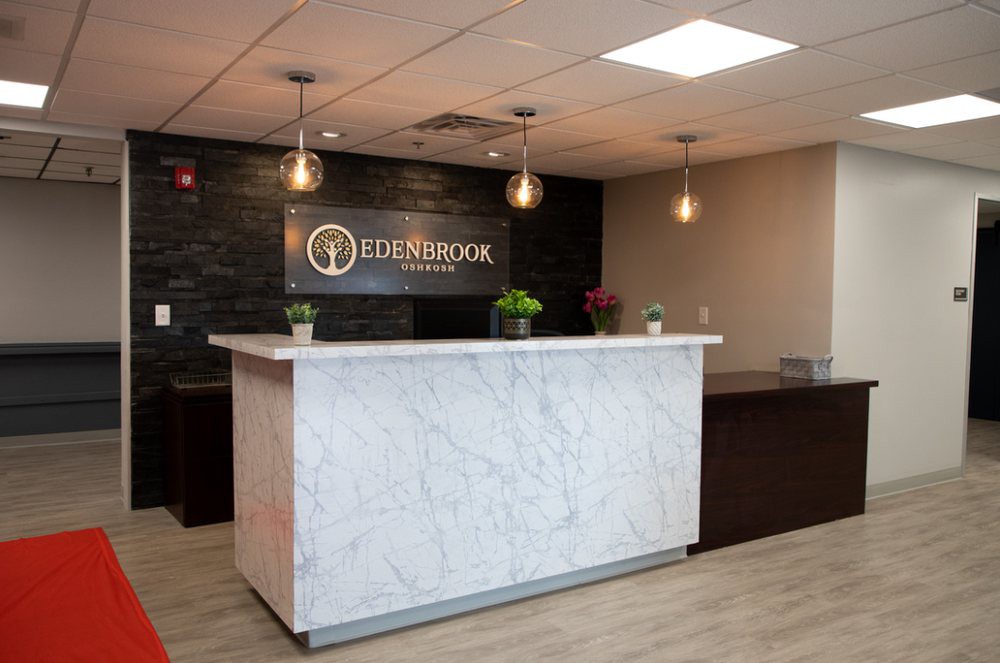 A modern office reception area with a marble counter and stylish lighting.