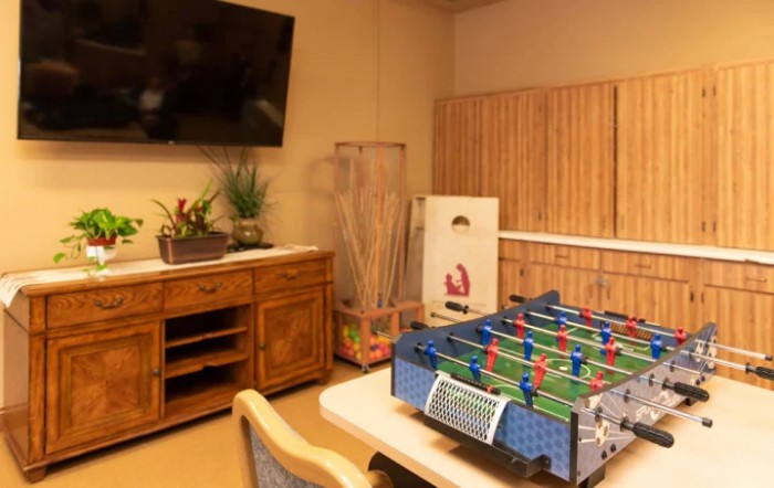 A cozy game room featuring a foosball table and a wall-mounted TV.