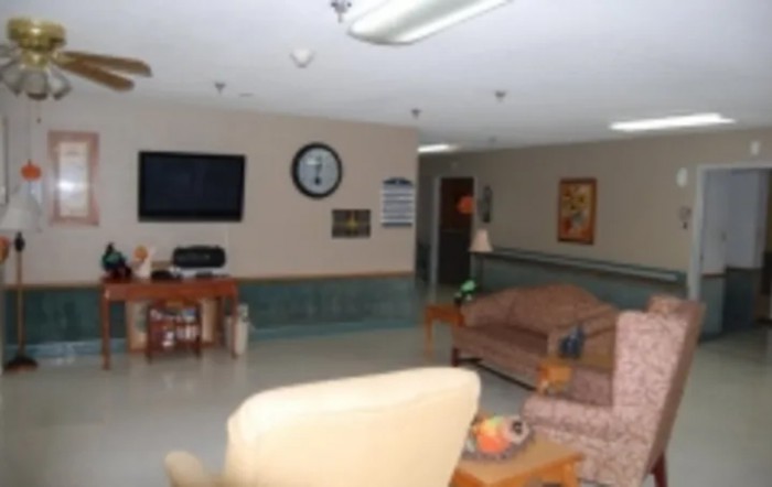 A cozy lounge area featuring sofas, a TV, and a clock on the wall.