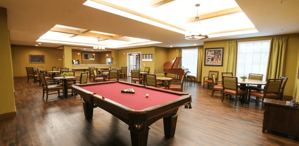 A cozy game room featuring a billiards table and bar area.