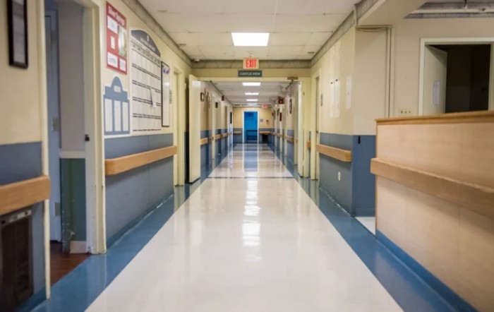 A clean and well-lit hospital corridor with a blue and white color scheme.