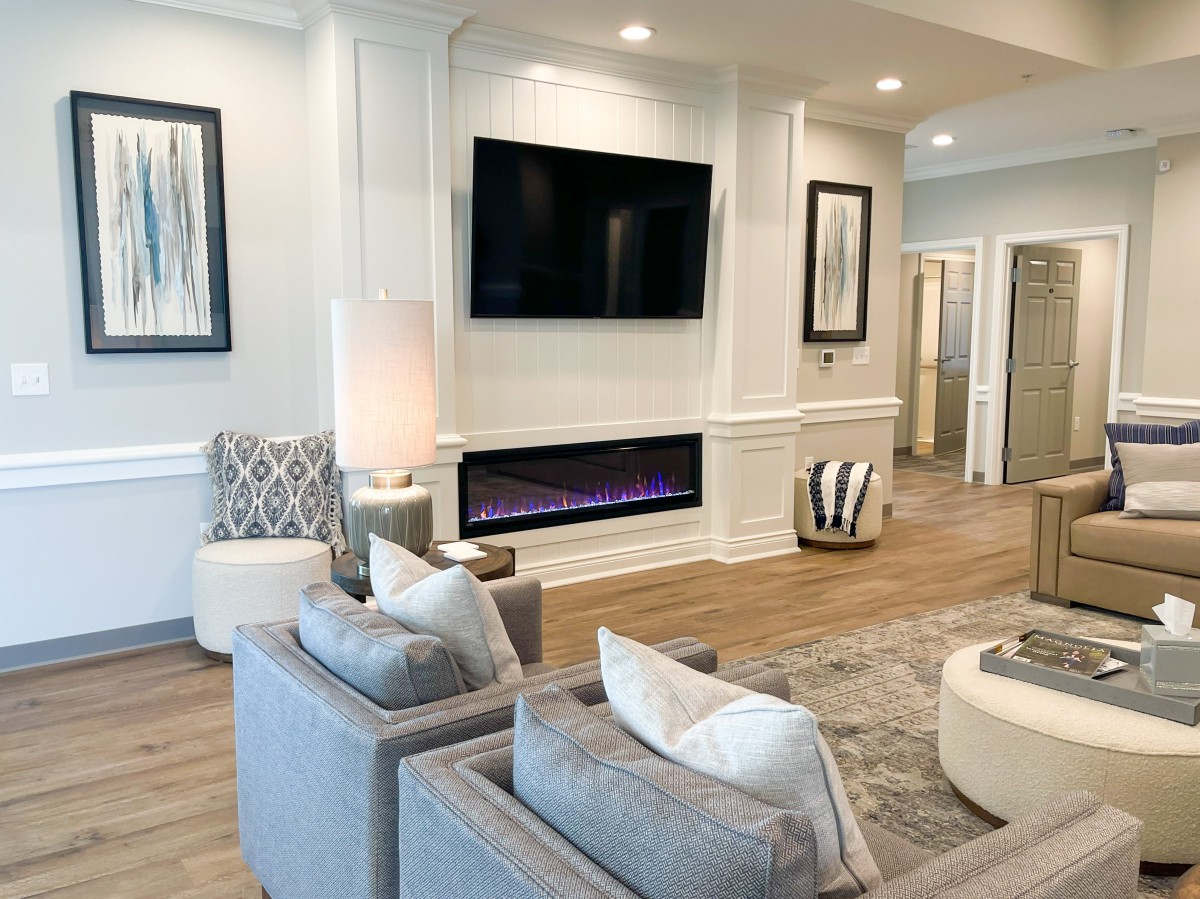 A modern living room featuring a large television, contemporary fireplace, and stylish seating area.