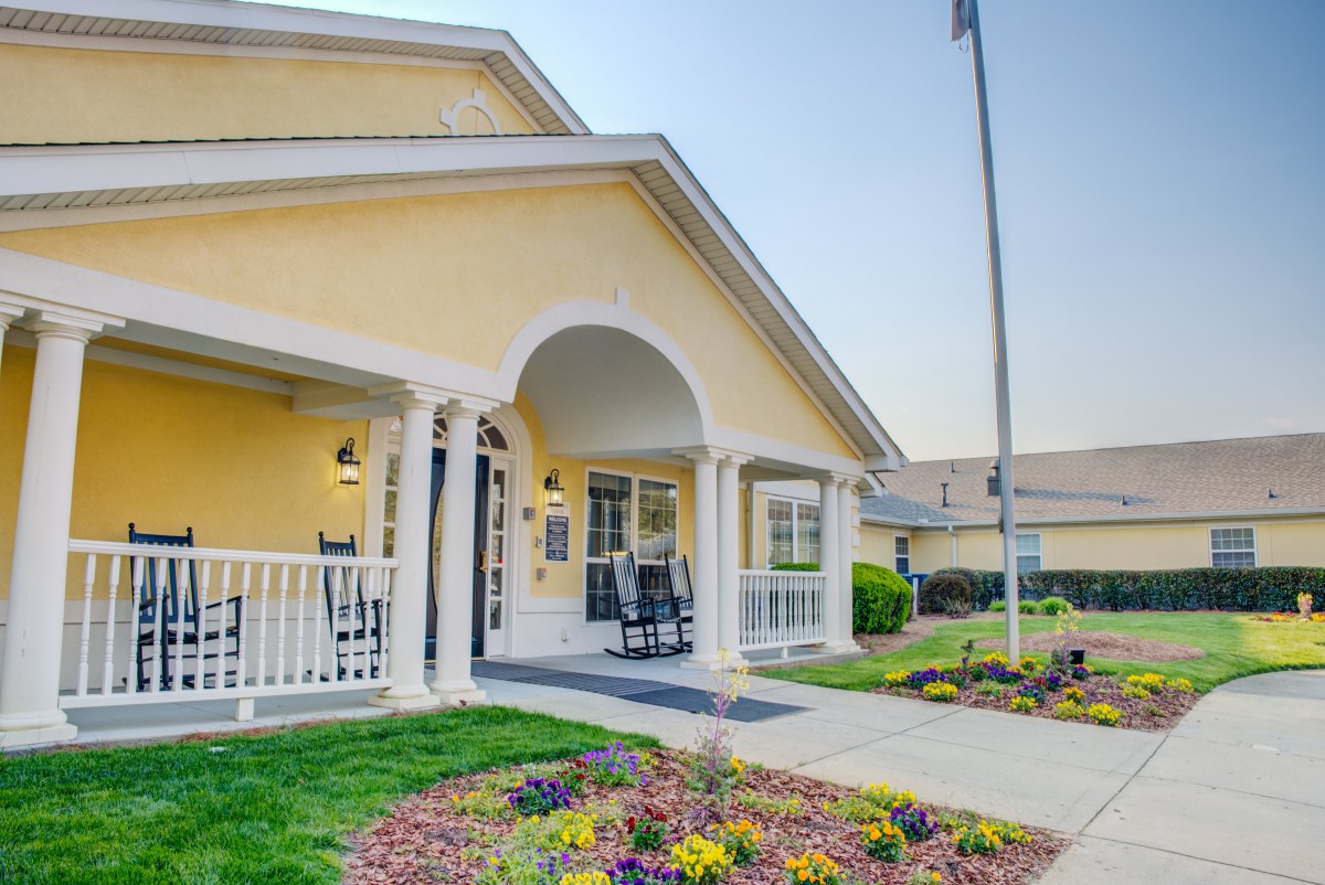 A charming house with a welcoming porch and a beautifully landscaped garden.