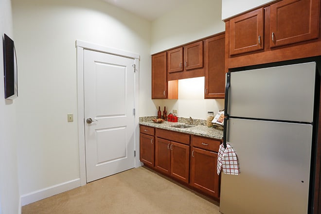 A modern kitchen with wooden cabinets, stainless steel appliances, and a spacious countertop.