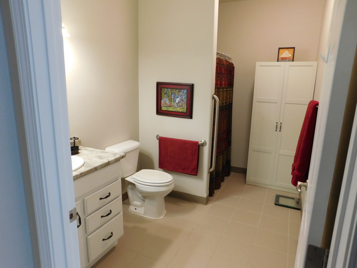 A modern bathroom with a toilet, sink, and storage cabinet.