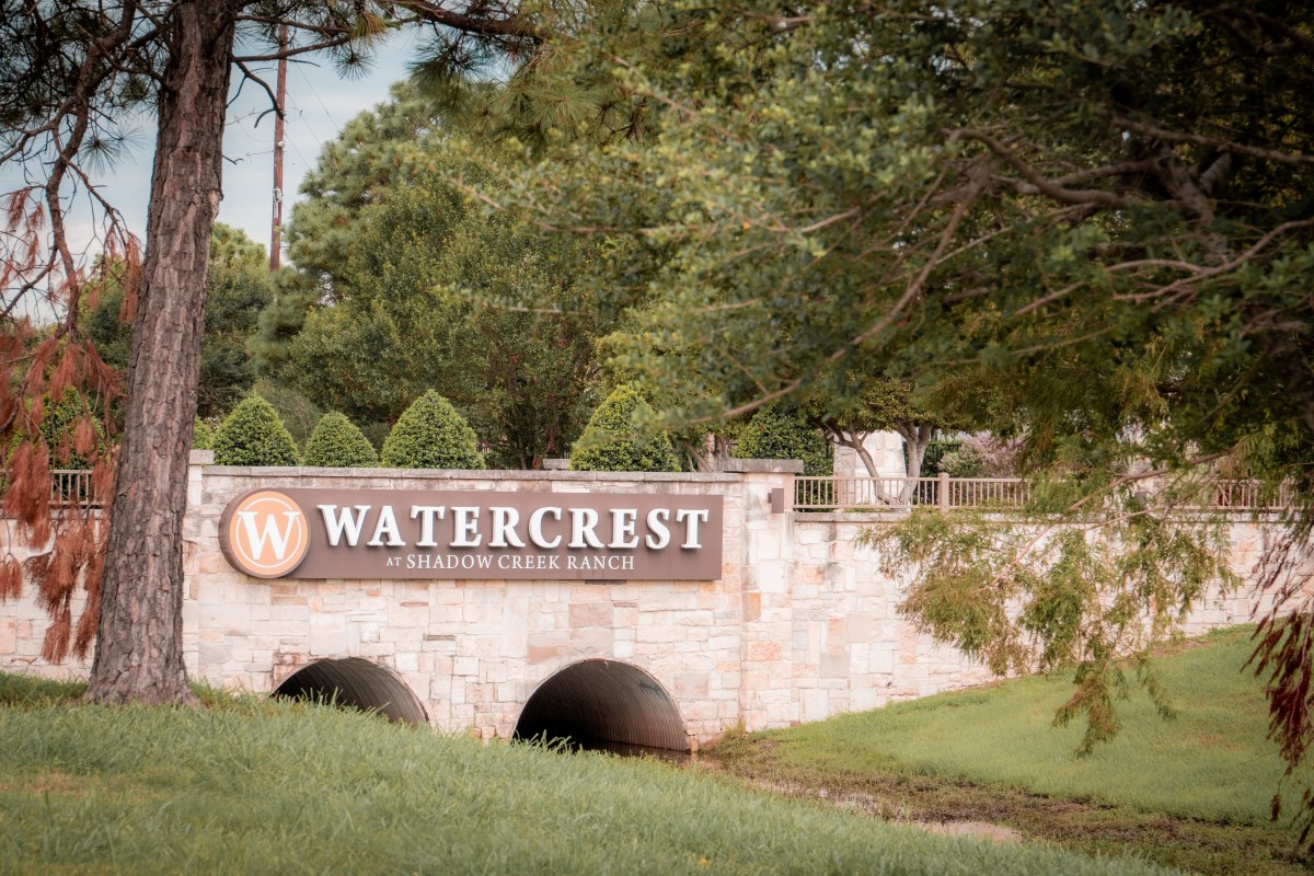Entrance sign for Watercrest set against a lush, green landscape.