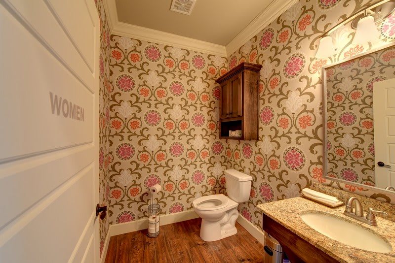 A cozy bathroom with floral wallpaper and warm lighting.