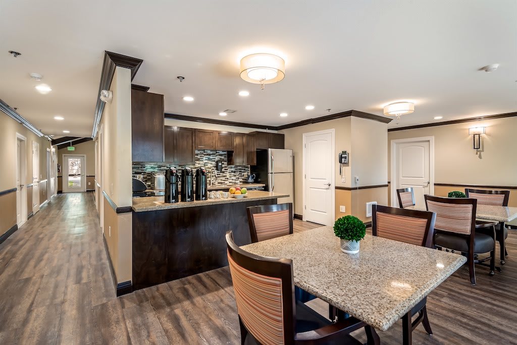 A modern kitchen and dining area with elegant furnishings and wooden flooring.