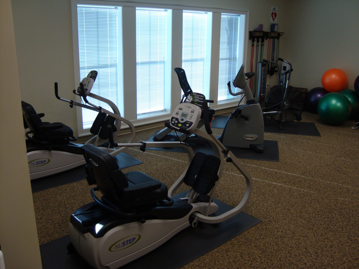 A gym with exercise equipment including treadmills and stationary bikes.