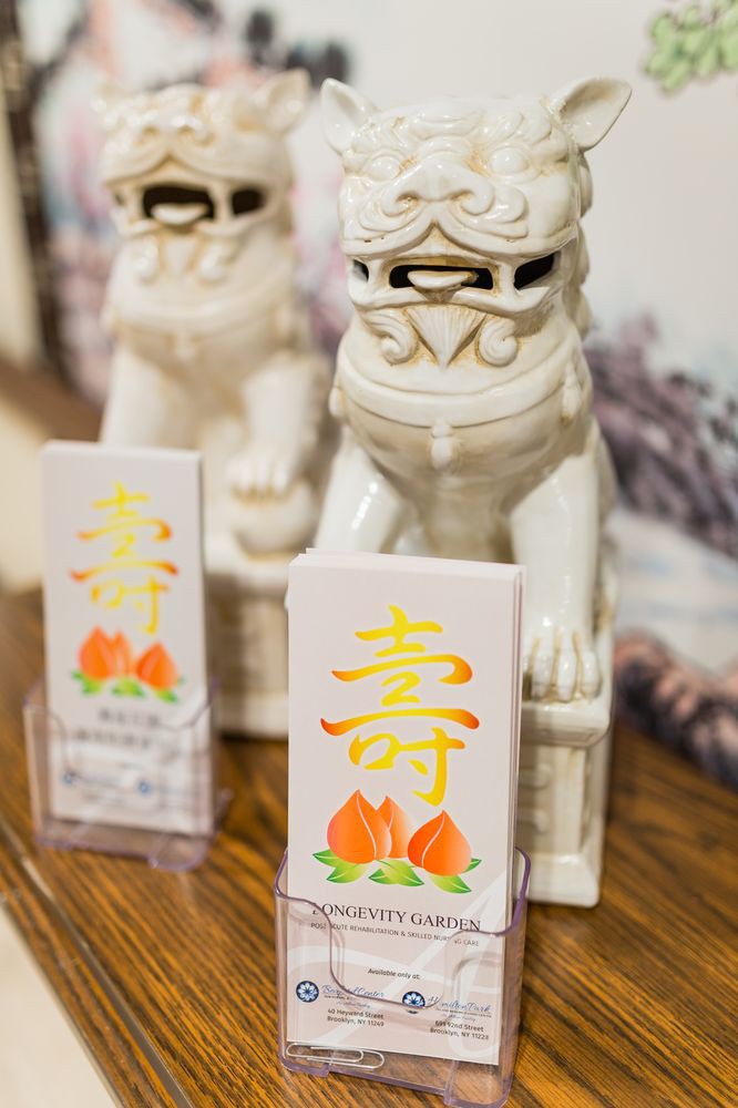 Ceramic guardian lion statues with decorative cards featuring Chinese characters and peach motifs.
