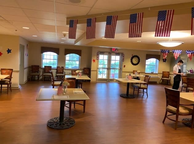 A spacious dining area decorated with American flags, featuring multiple tables and chairs.