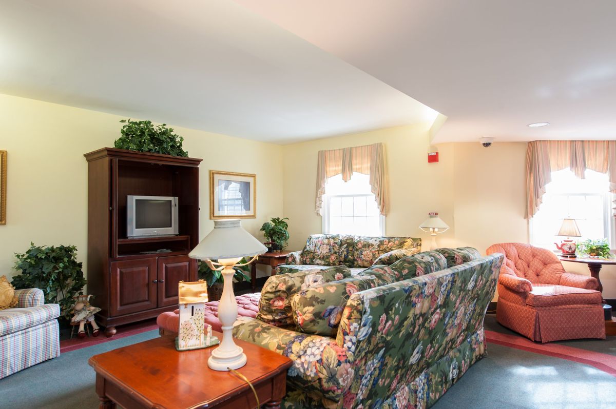 A cozy living room with floral sofas and a television.