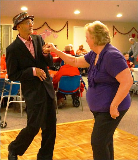 Two people dancing joyfully at a social event.