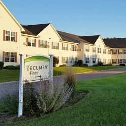 A senior living facility with a well-maintained exterior and green lawn.