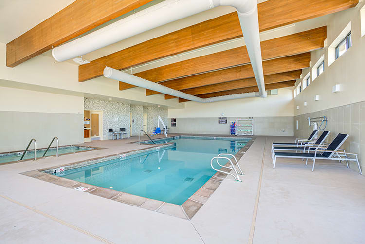 An indoor swimming pool featuring seating and modern architectural design.