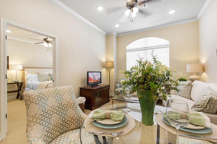 A cozy living room with an elegant dining area, featuring a floral centerpiece and tasteful decor.