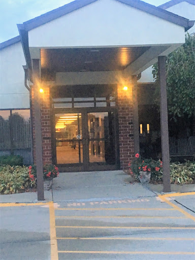 An inviting entrance of a modern building illuminated in the evening light.