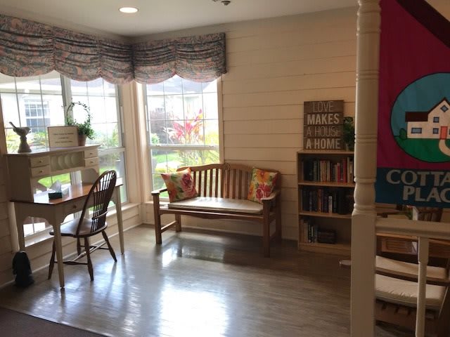 Bright and cozy living room with a bench and bookshelf.