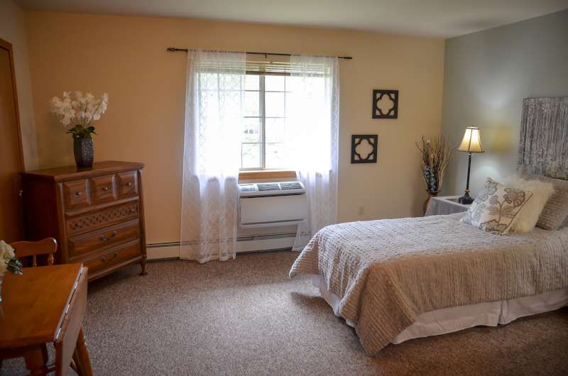 A cozy bedroom with natural light and simple decor.