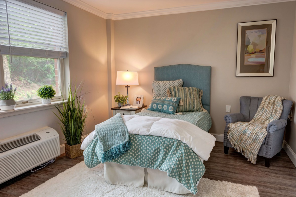 A cozy bedroom with a neatly made bed, soft lighting, and tasteful decor.