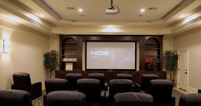 A cozy home theater setup with comfortable seating and a large projector screen.