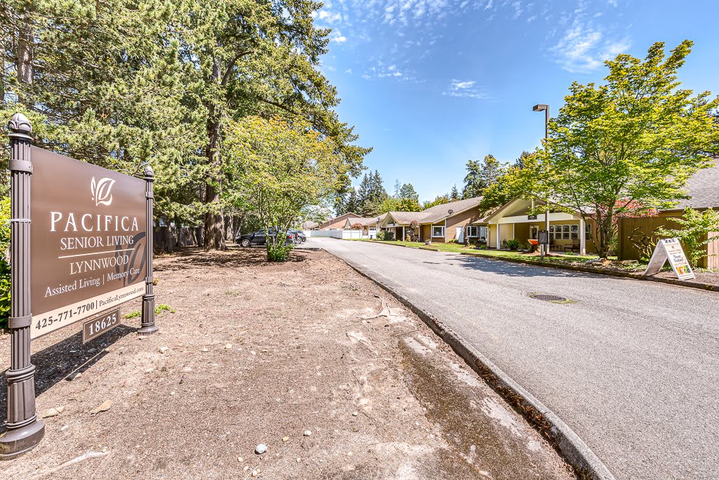 A quiet road lined with trees and buildings on a clear day.