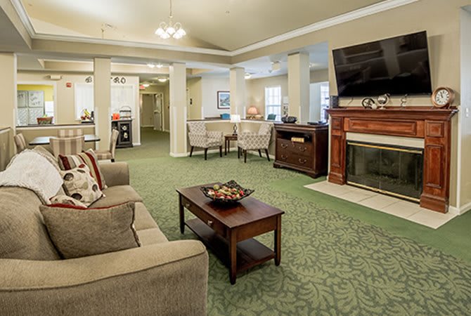 A cozy living room with a comfortable sofa, coffee table, fireplace, and television.