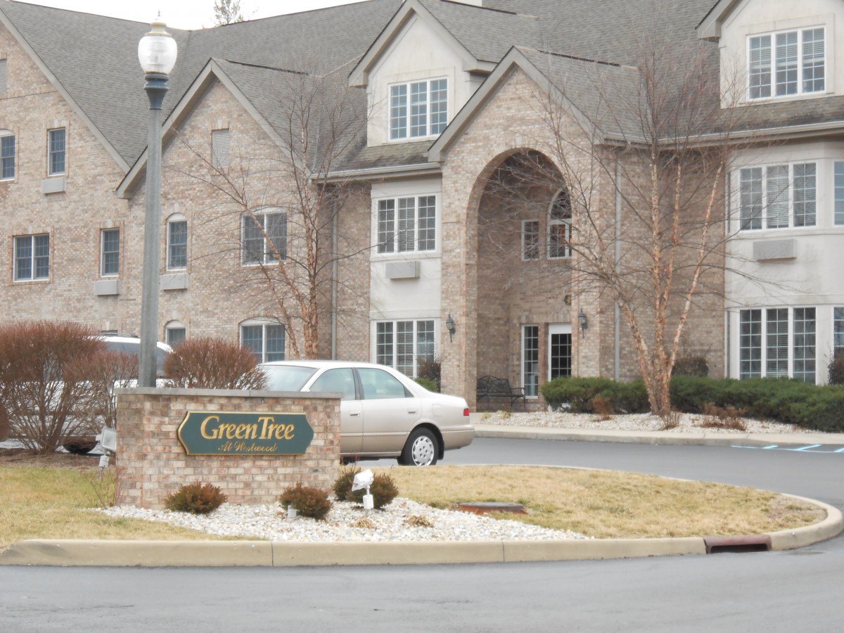 A residential apartment complex with a parked car in front.