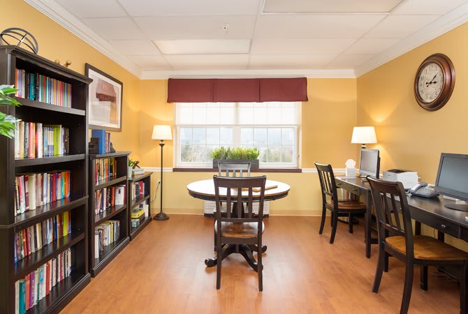 A well-lit office space with desks, chairs, and bookshelves.