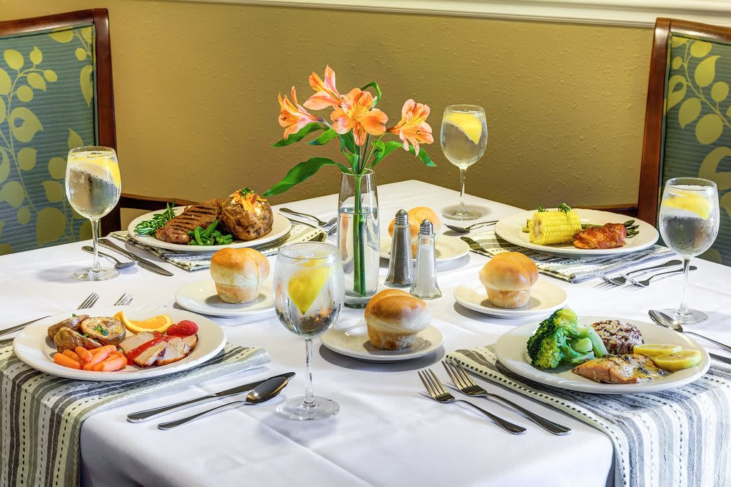 A beautifully set dining table with elegant dinnerware and floral centerpiece.
