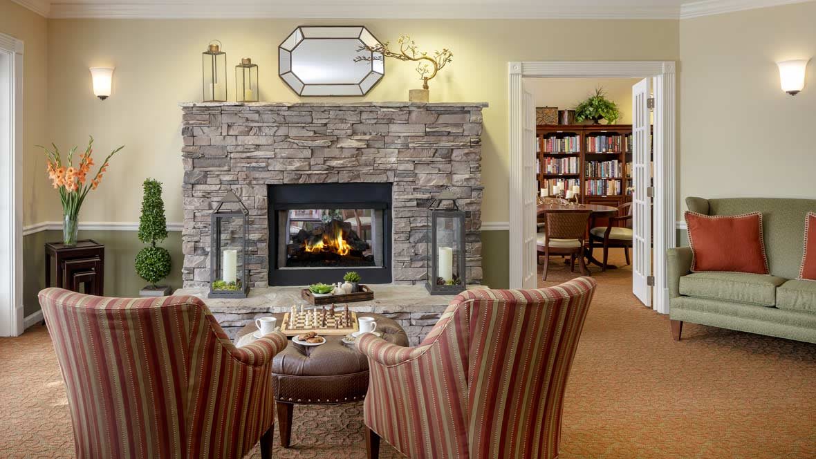 A cozy living room with a stone fireplace and comfortable seating.
