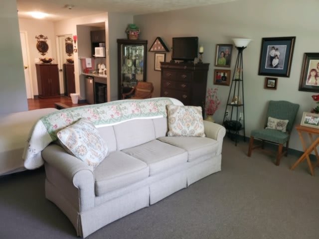 A cozy living room with a sofa, various furniture pieces, and decorative elements.